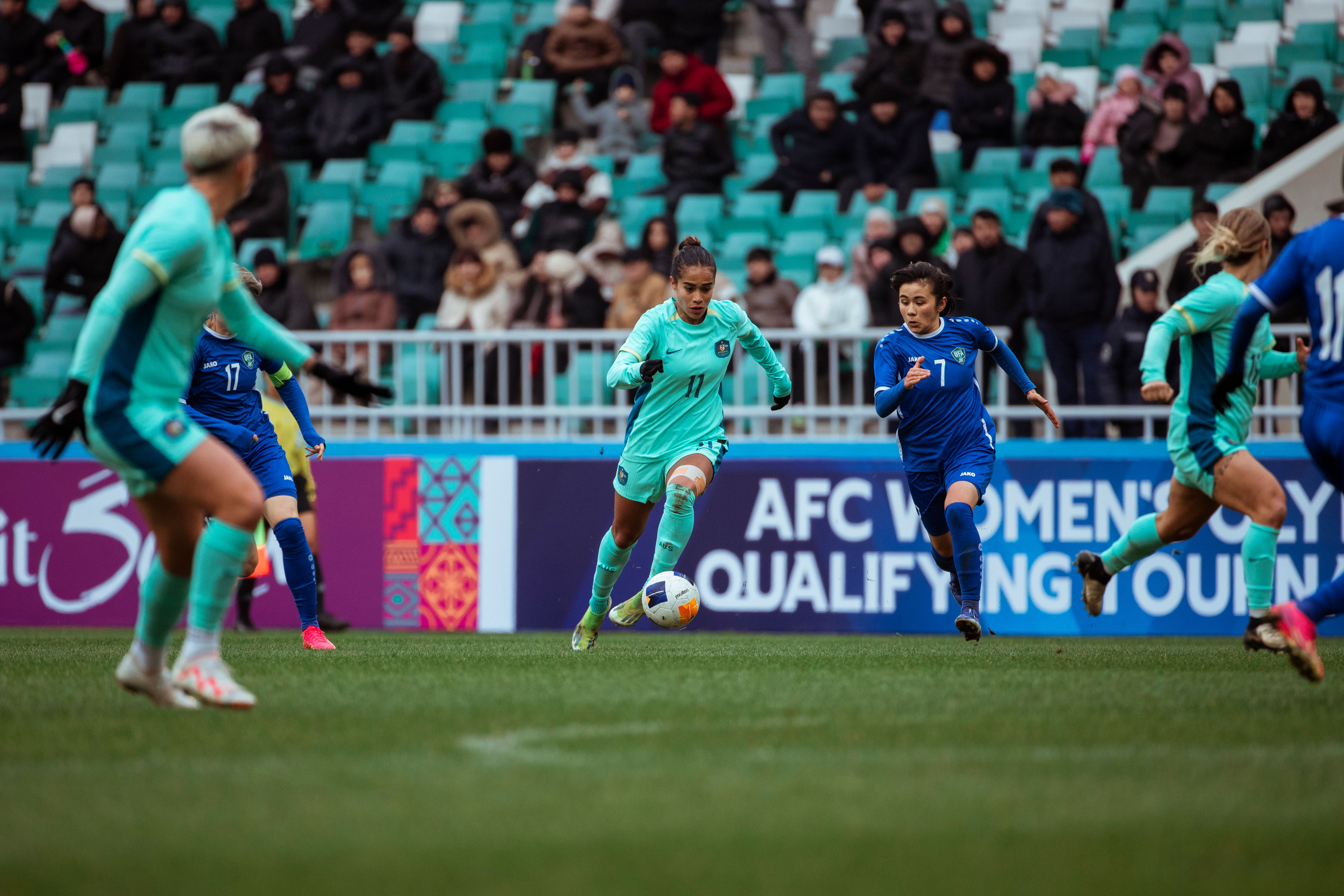 Mary Fowler picks up the ball and runs at Uzbekistan's defence. (Photo: Tiffany Williams/Football Australia)