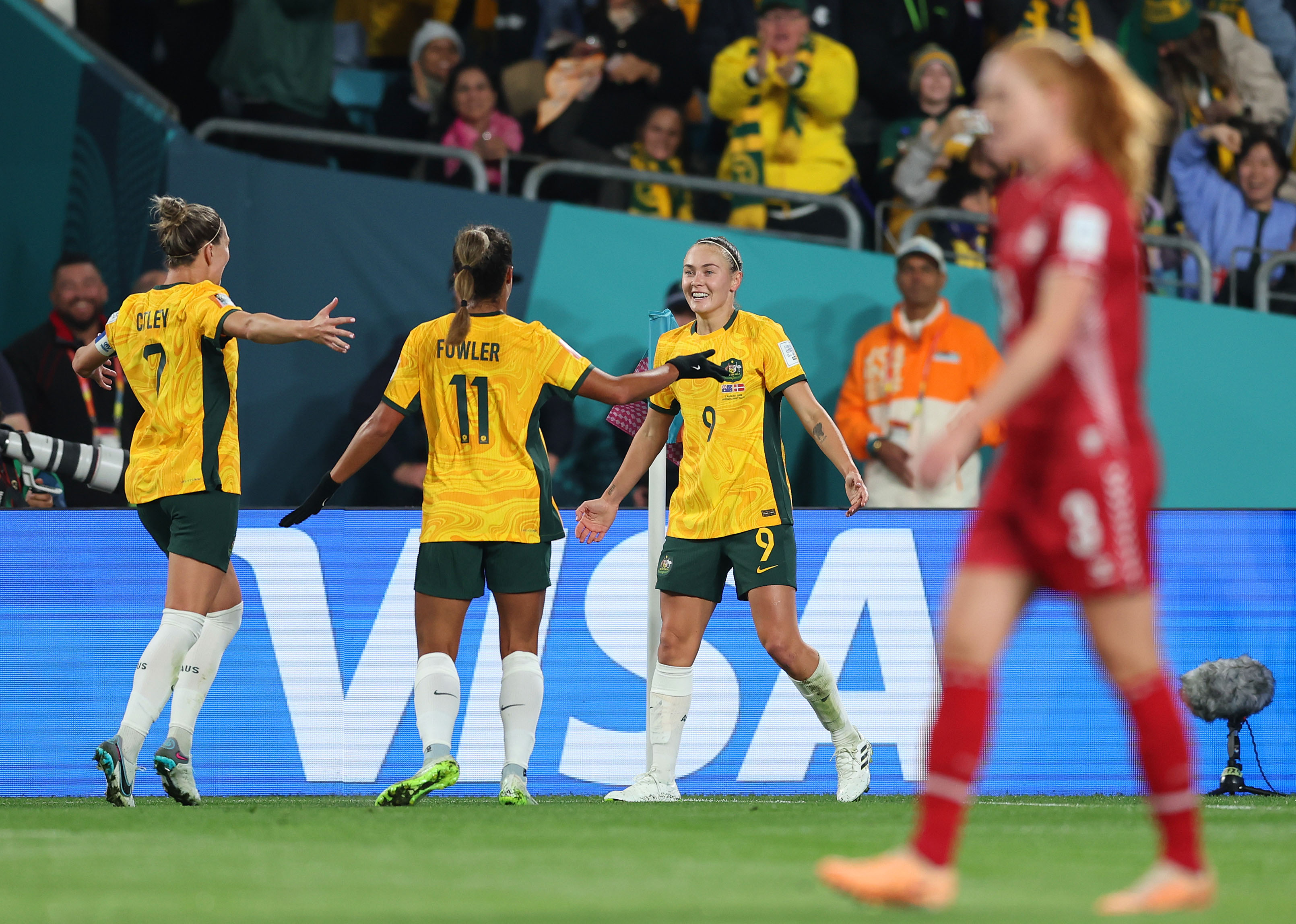 Caitlin Foord of Australia celebrates with Steph Catley and Mary Fowler of Australia after scoring her team's first goal during the FIFA Women's World Cup Australia & New Zealand 2023 Round of 16 match between Australia and Denmark at Stadium Australia on August 07, 2023 in Sydney, Australia. (Photo by Matt King - FIFA/FIFA via Getty Images)