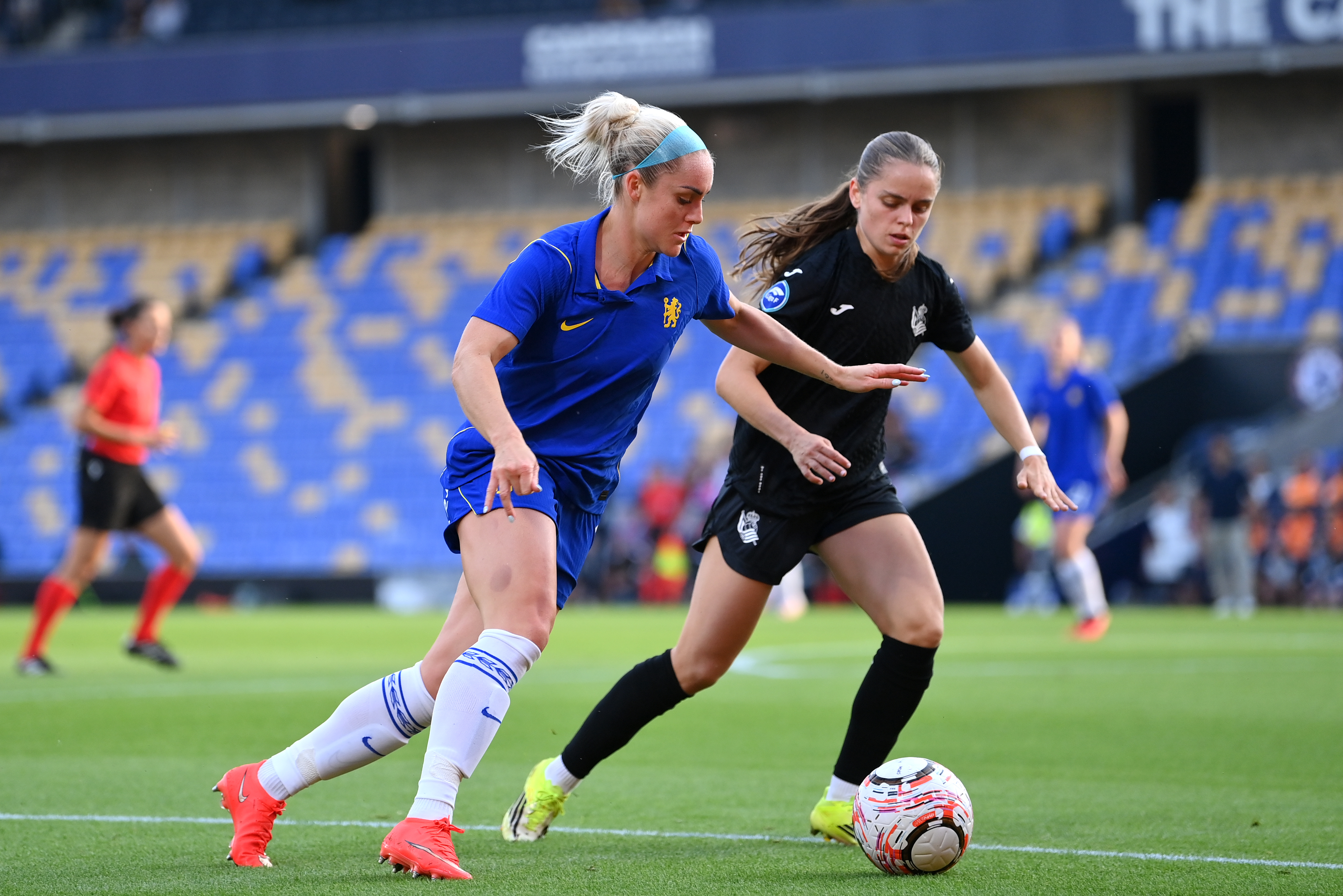 Ellie Carpenter of Chelsea is challenged by Cecilia Marcos of Real Sociedad during the UEFA Women's Champions League Third Qualifying Round First Leg match between Chelsea and Real Sociedad on August 26, 2026 in Wimbledon, England. (Photo by Patrick Khachfe/Getty Images)