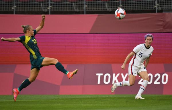 USA's forward Megan Rapinoe (R) kicks the ball while Australia's midfielder Tameka Yallop (L) attempts to block during second half of the Tokyo 2020 Olympic Games women's group G first round football match between USA and Australia at the Ibaraki Kashima Stadium in Kashima city, Ibaraki prefecture on July 27, 2021. (Photo by SHINJI AKAGI / AFP) (Photo by SHINJI AKAGI/AFP via Getty Images)