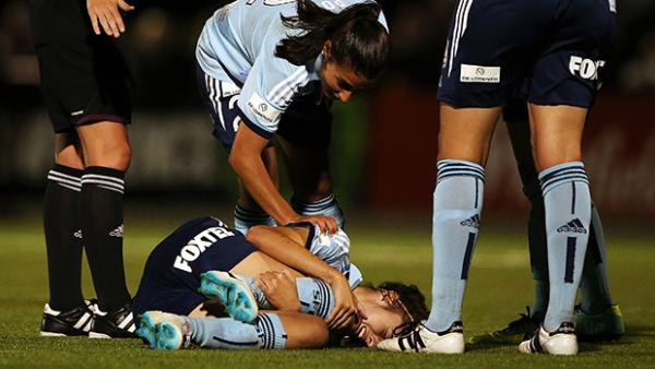 Sydney FC players check on the welfare of an injured Amy Harrison.