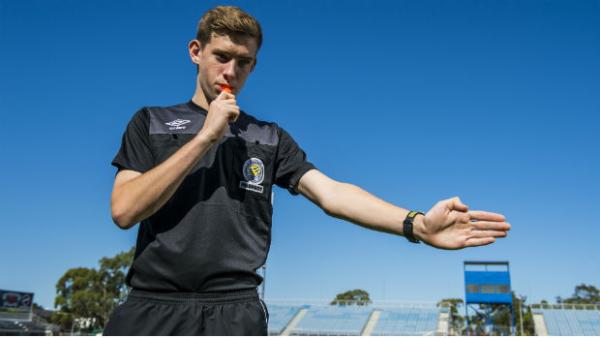 A referee takes charge of a local football match.