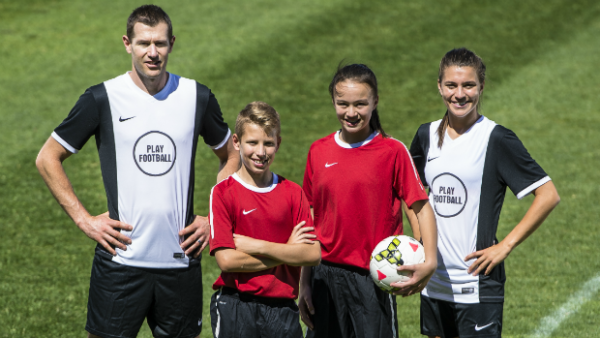 Play Football ambassadors Brett Emerton and Steph Catley with two young football stars.